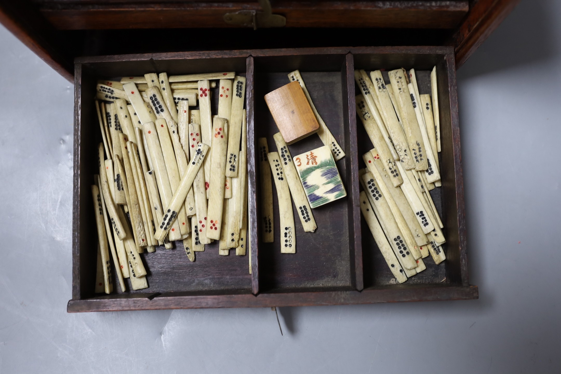 An early 20th century Chinese hardwood cased bone and bamboo mahjong set